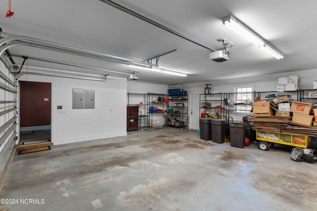 garage with a garage door opener and electric panel