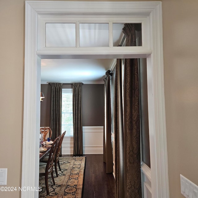 corridor with dark hardwood / wood-style floors and crown molding