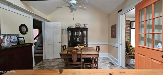 tiled dining space featuring ceiling fan and lofted ceiling