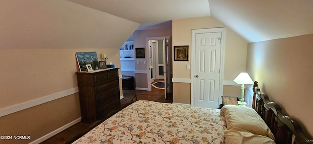 bedroom with dark hardwood / wood-style floors and vaulted ceiling