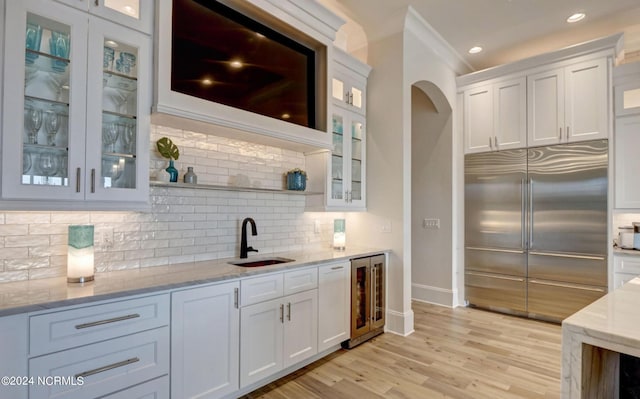 kitchen with white cabinets, sink, wine cooler, and stainless steel built in refrigerator