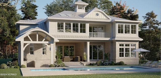 rear view of house featuring a patio and a balcony