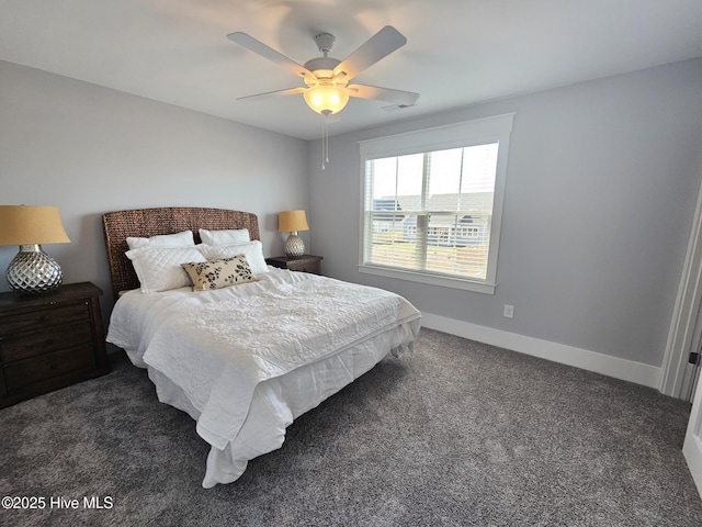 bedroom with visible vents, a ceiling fan, baseboards, and dark carpet