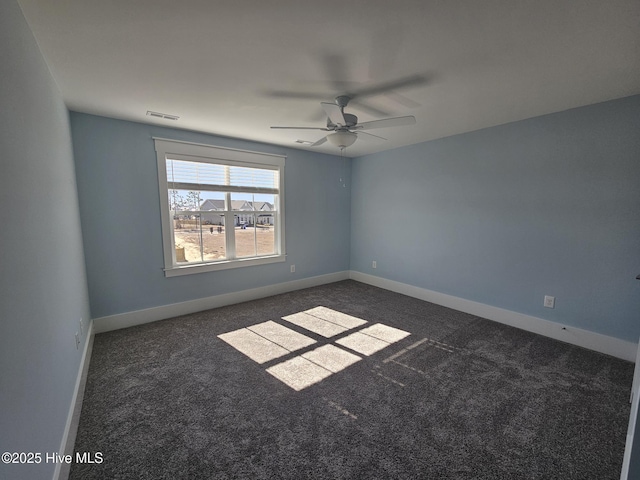 empty room featuring ceiling fan and dark colored carpet