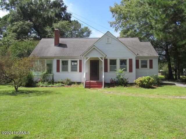 view of front of house featuring a chimney and a front yard