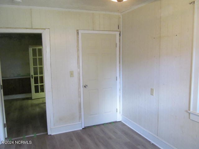 unfurnished bedroom featuring wood-type flooring and crown molding