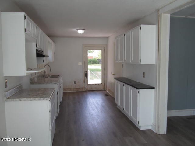 kitchen with dark wood-type flooring, sink, and white cabinetry