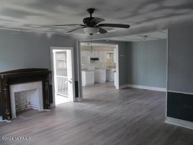 unfurnished living room featuring hardwood / wood-style floors and ceiling fan