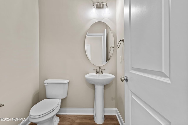 bathroom with hardwood / wood-style flooring, sink, and toilet