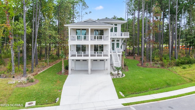 view of front of house featuring a garage, a front lawn, and a balcony