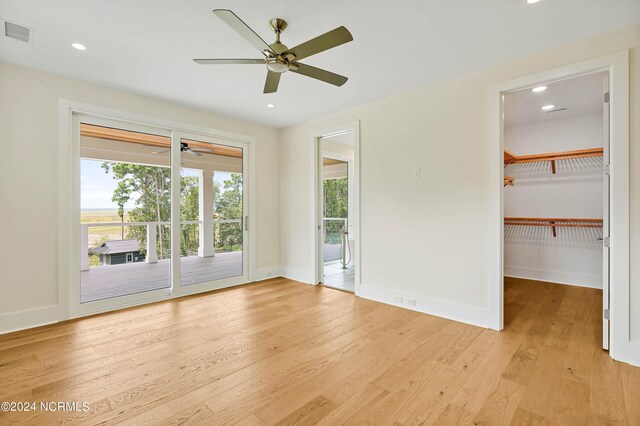 living room with a fireplace, ceiling fan with notable chandelier, and light hardwood / wood-style flooring