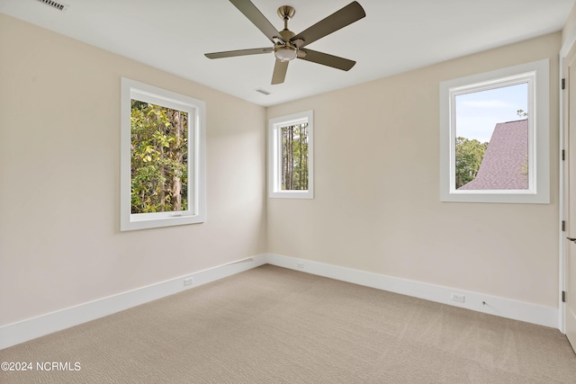 spare room featuring light carpet and ceiling fan