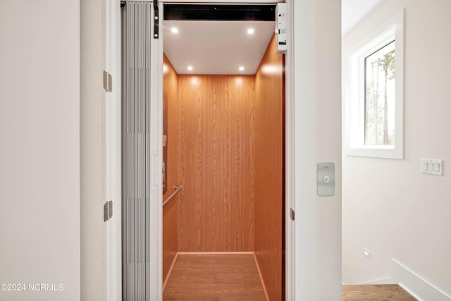 interior details with hardwood / wood-style flooring and elevator