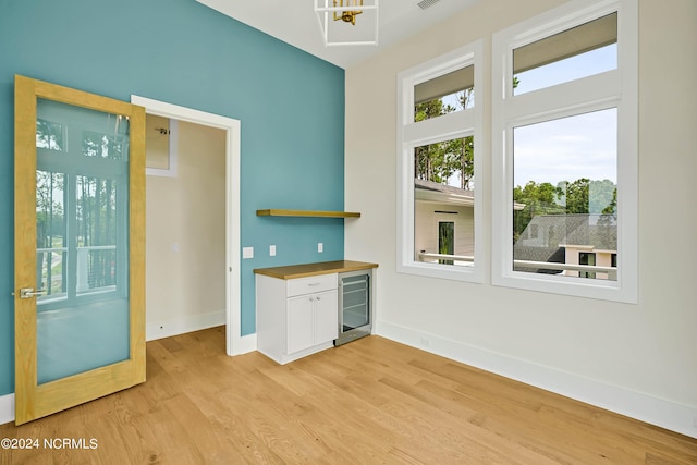 interior space featuring beverage cooler and light hardwood / wood-style flooring