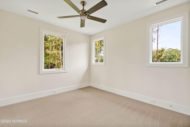 carpeted empty room with a healthy amount of sunlight and ceiling fan