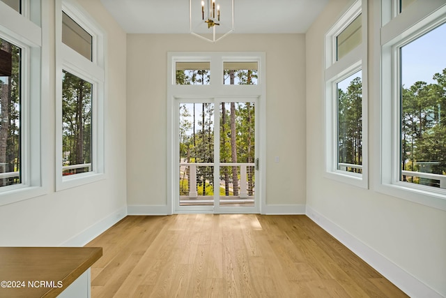 unfurnished sunroom featuring plenty of natural light and a notable chandelier