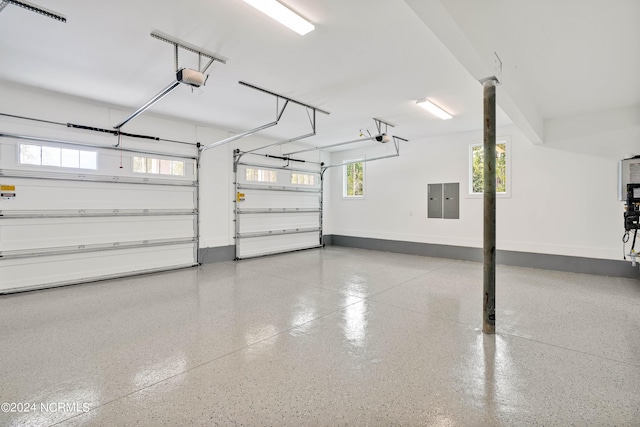 garage with a garage door opener and electric panel