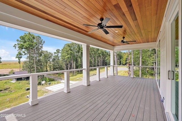 wooden deck featuring ceiling fan and a yard