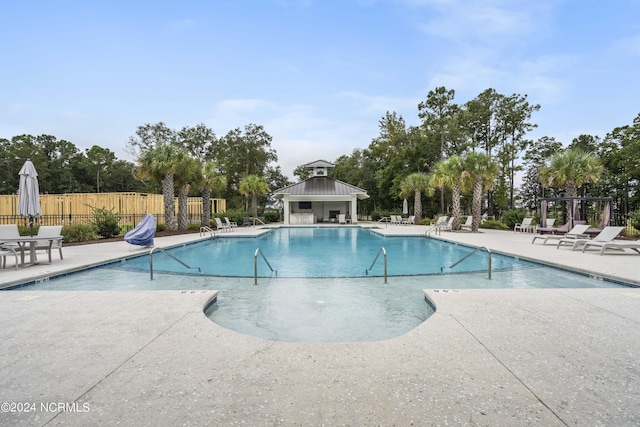 view of swimming pool with an outdoor structure and a patio area