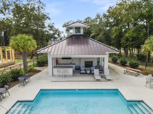 view of pool with an outdoor structure, an outdoor bar, and a patio