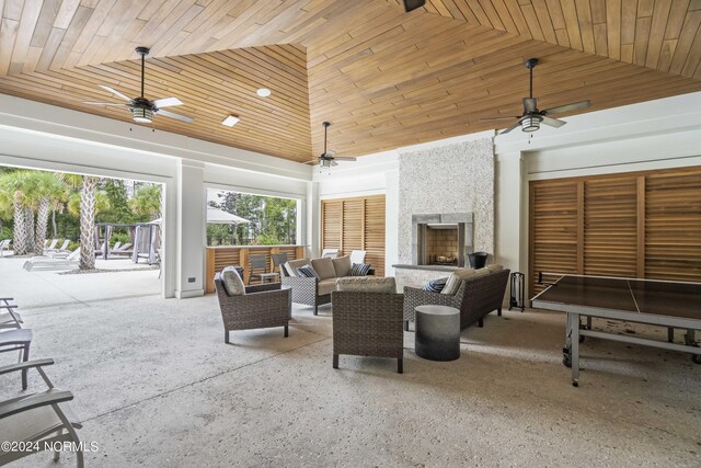 view of patio with an outdoor living space with a fireplace and ceiling fan