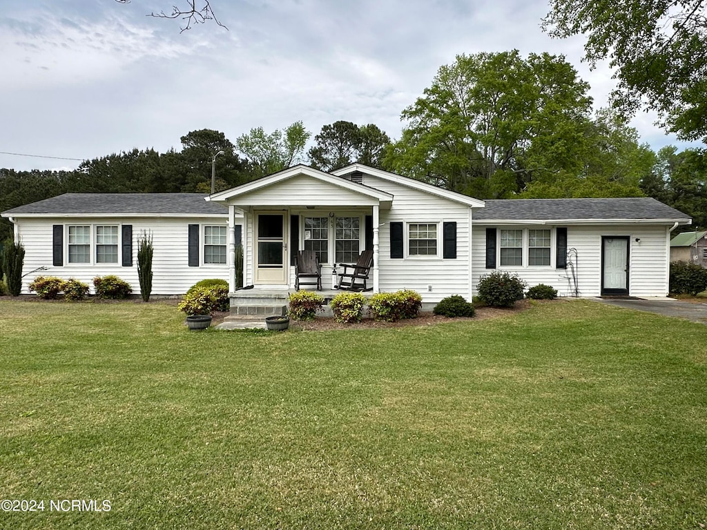 ranch-style house featuring covered porch and a front yard