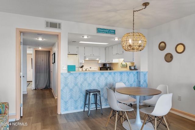 dining room with a notable chandelier and dark hardwood / wood-style floors