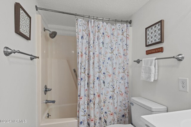 full bathroom with vanity, a textured ceiling, toilet, and shower / bath combo with shower curtain