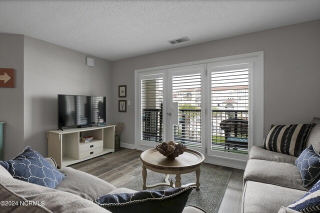 living room with a textured ceiling and light hardwood / wood-style flooring