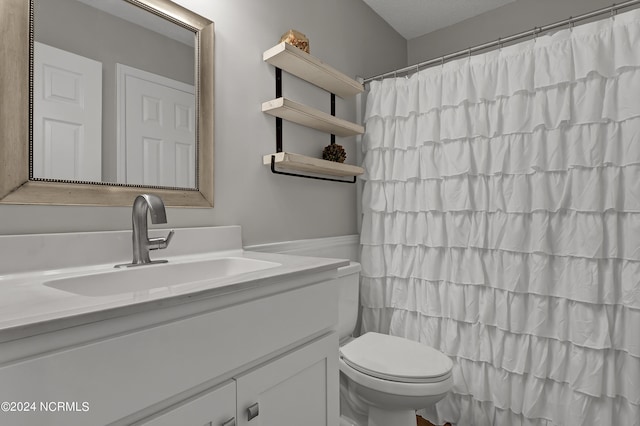 bathroom with a shower with curtain, vanity, and toilet