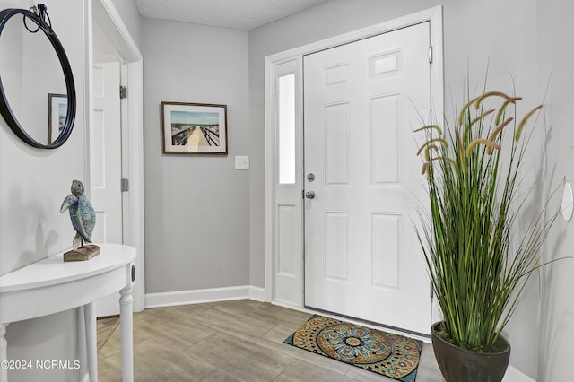 foyer entrance with a textured ceiling