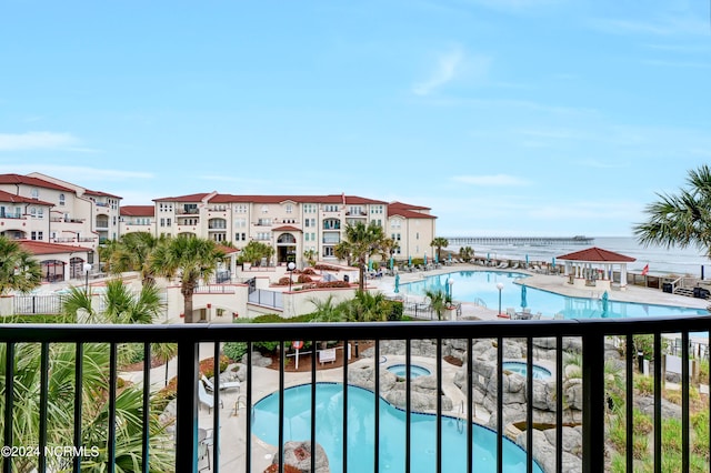 view of swimming pool featuring a patio and a water view