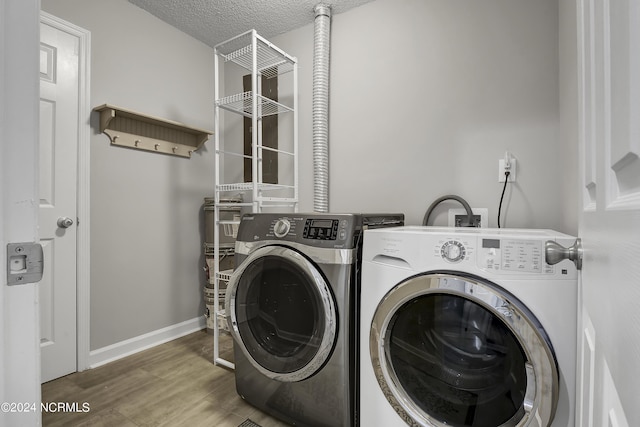 laundry room with dark wood-type flooring, independent washer and dryer, and a textured ceiling