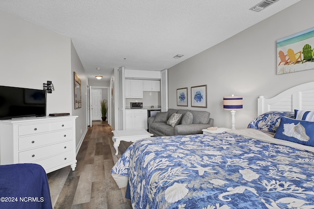 bedroom with dark wood-type flooring and a textured ceiling