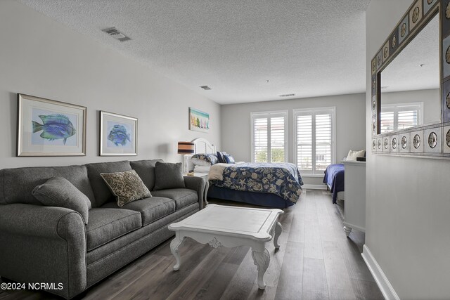 bedroom with hardwood / wood-style flooring and a textured ceiling