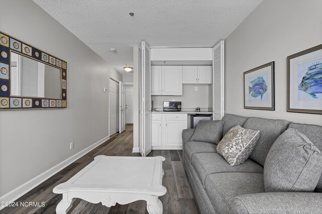 living room with dark wood-type flooring and a textured ceiling