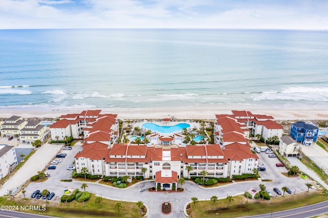 birds eye view of property with a water view and a beach view