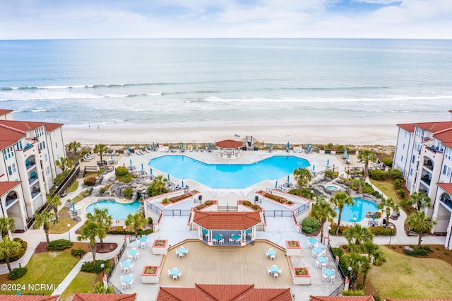 bird's eye view featuring a water view and a beach view