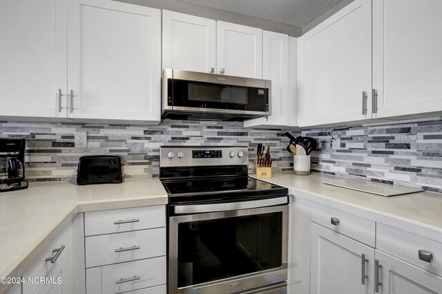 kitchen with white cabinetry, backsplash, stainless steel appliances, and a textured ceiling