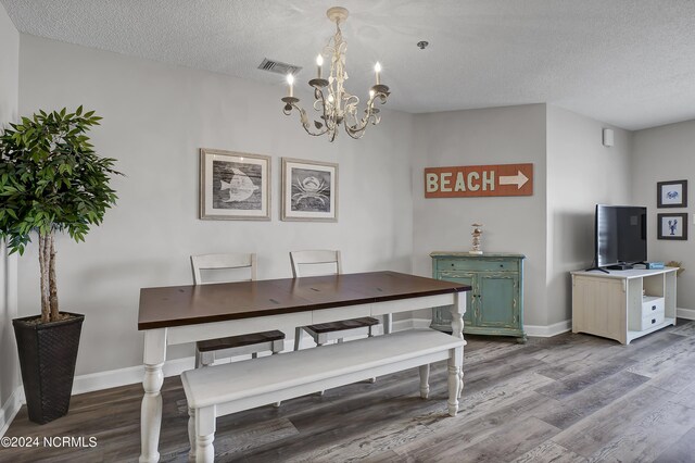 dining space with an inviting chandelier, hardwood / wood-style floors, and a textured ceiling