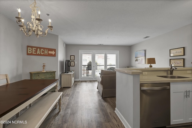 kitchen with sink, dark wood-type flooring, dishwasher, white cabinetry, and hanging light fixtures