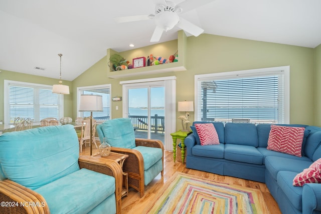 living room with a water view, lofted ceiling, ceiling fan, and light hardwood / wood-style flooring