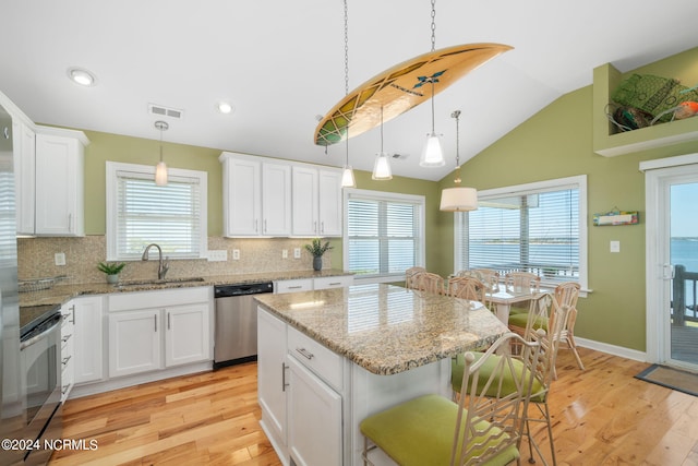 kitchen with white cabinetry, stainless steel appliances, a center island, and sink