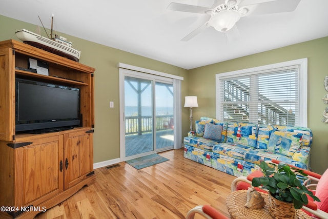 living room with ceiling fan and light hardwood / wood-style flooring