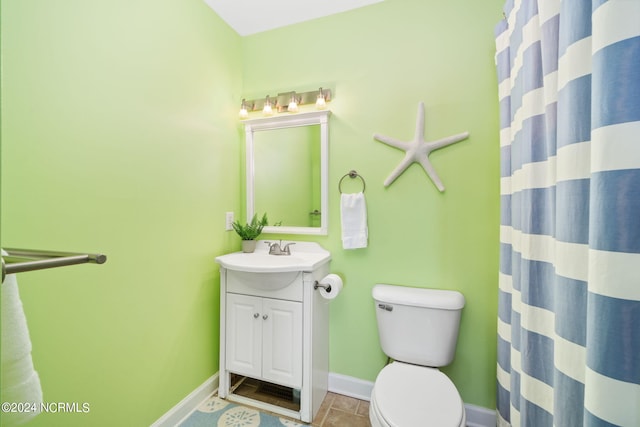 bathroom with vanity, curtained shower, tile patterned floors, and toilet