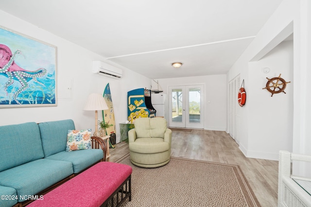 living room with an AC wall unit, light hardwood / wood-style flooring, and french doors