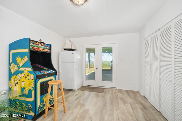 recreation room featuring french doors and light hardwood / wood-style floors