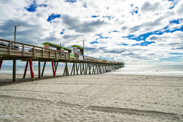 dock area featuring a water view and a beach view