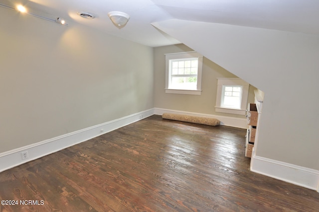 bonus room with lofted ceiling and dark wood-type flooring