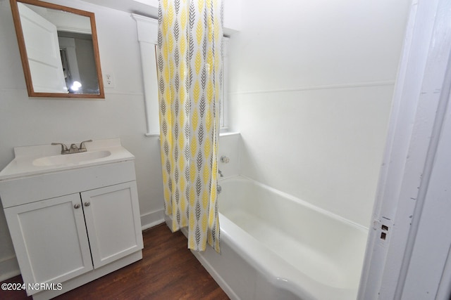 bathroom featuring hardwood / wood-style flooring, oversized vanity, and shower / bath combo